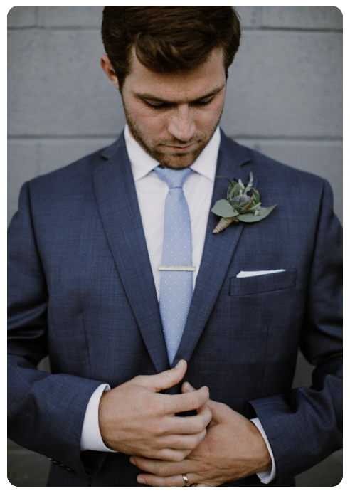Groom in navy blue suit with eucalyptus boutonniere